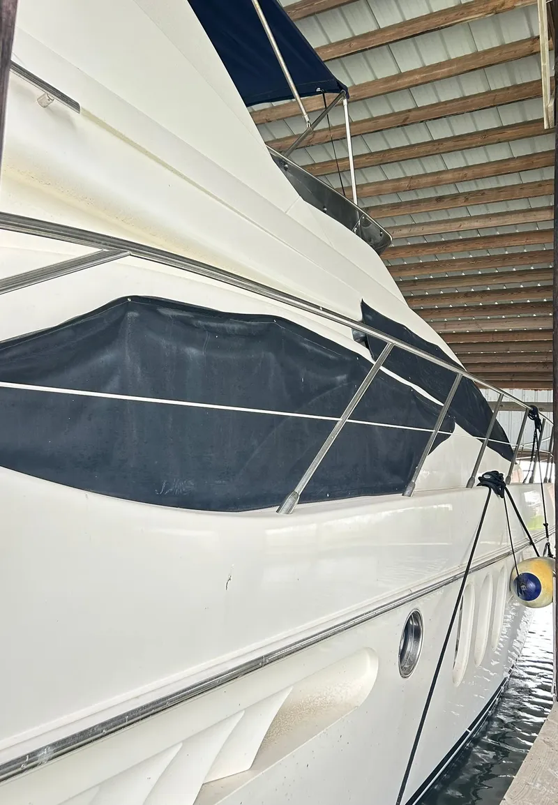 Slide: The Image of 2006 Azimut 62 yacht docked under a covered marina. - 19