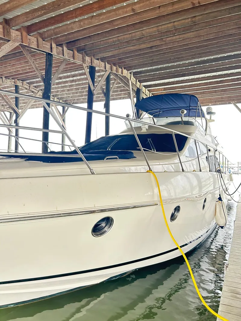Slide: The Image of 2006 Azimut 62 yacht docked under a wooden shelter. - 23