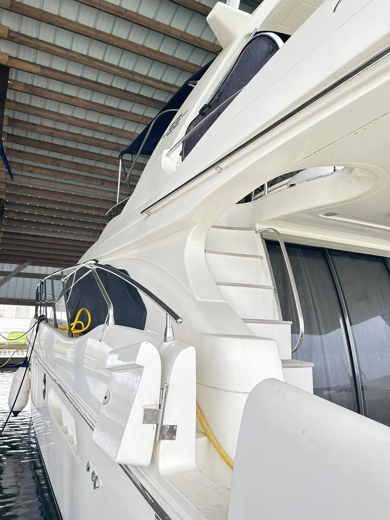Slide: The Image of 2006 Azimut 62 yacht docked under a covered marina. - 27
