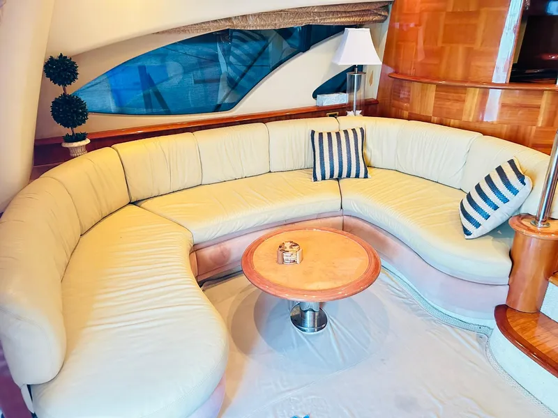 Slide: The Image of Luxurious interior of a 2006 Azimut 62 yacht with elegant curved seating and striped cushions. - 49