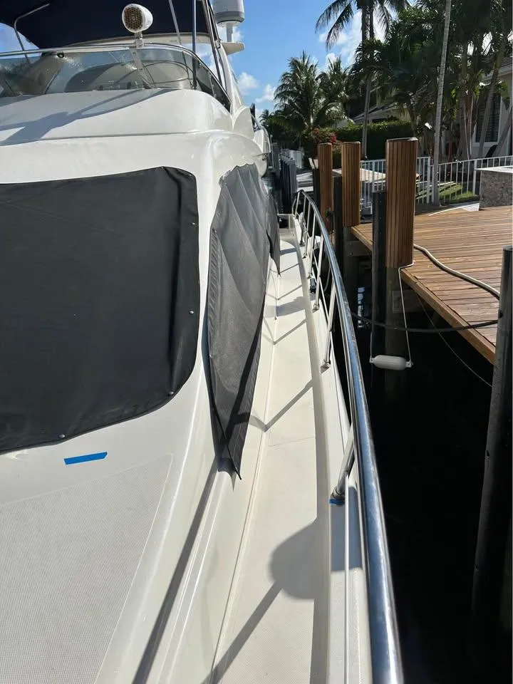 Slide: The Image of 2006 Azimut 62 yacht docked, side view with palm trees and clear sky. - 5