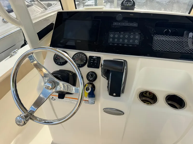 Slide: The Image of 2023 Scout 215 XSF boat dashboard with steering wheel, controls, and gauges. - 10