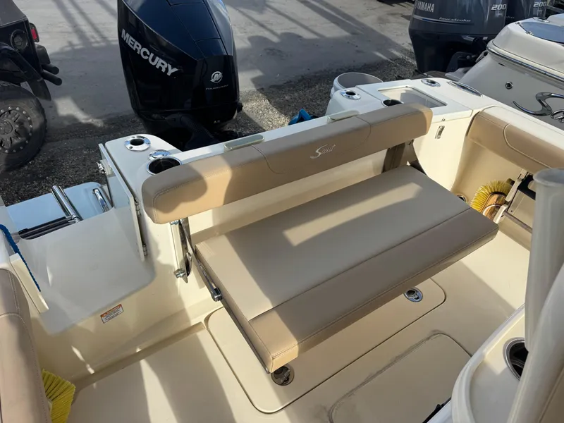Slide: The Image of 2023 Scout 215 XSF boat interior with beige seating and Mercury outboard motor. - 11