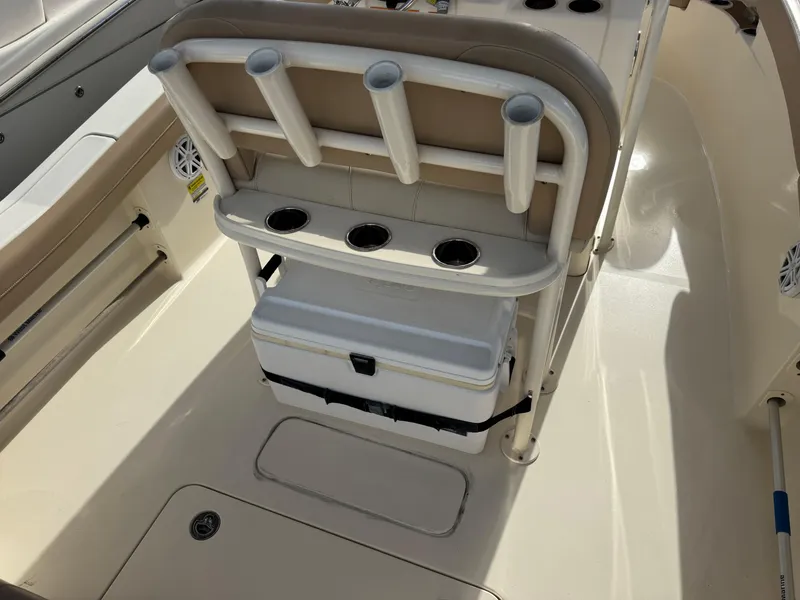 Slide: The Image of 2023 Scout 215 XSF boat interior with rod holders and cooler storage. - 12