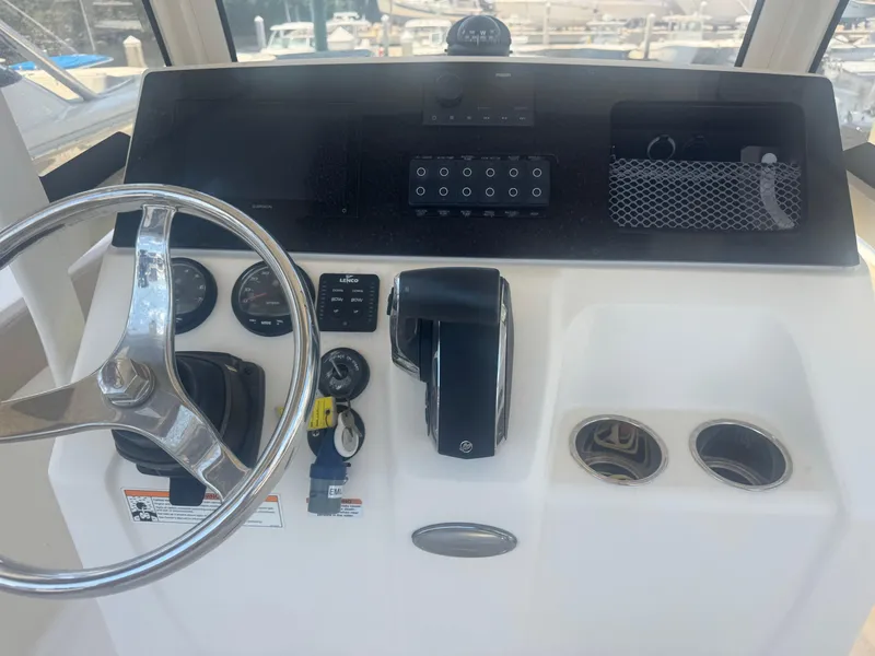 Slide: The Image of 2023 Scout 215 XSF boat dashboard with steering wheel and control panel. - 2