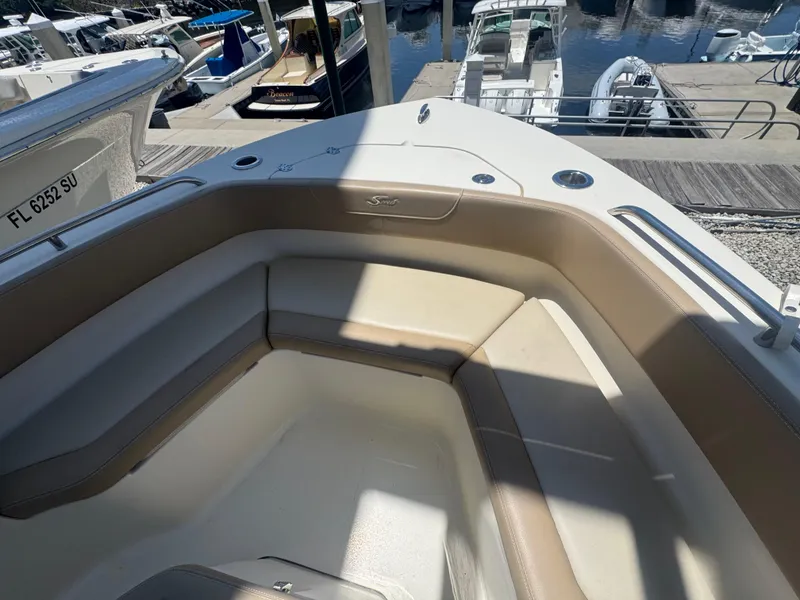 Slide: The Image of 2023 Scout 215 XSF boat interior with seating, docked at marina. - 3