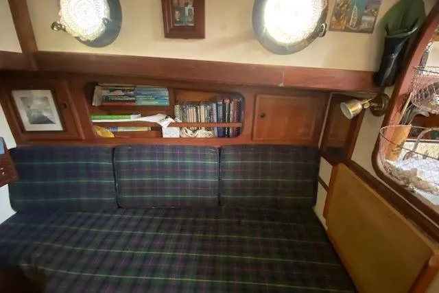 Slide: The Image of Cozy 1985 Bristol Channel Cutter 28 interior with plaid seating and bookshelf. - 18