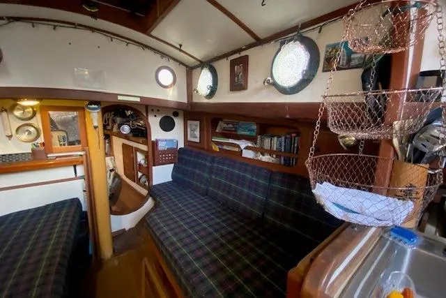 Slide: The Image of Interior of a 1985 Bristol Channel Cutter 28, featuring cozy seating and nautical decor. - 19
