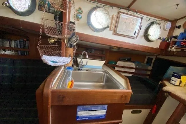 Slide: The Image of Interior of a 1985 Bristol Channel Cutter 28, featuring a compact kitchen area. - 22