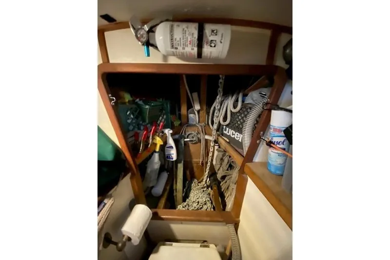 Slide: The Image of Interior of 1985 Bristol Channel Cutter 28 with storage, cleaning supplies, and fire extinguisher. - 26