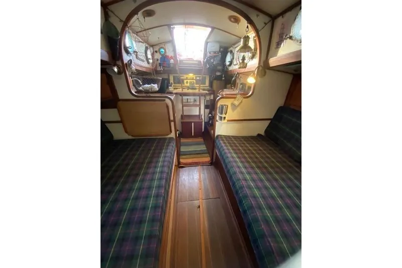 Slide: The Image of Interior of a 1985 Bristol Channel Cutter 28 sailboat, featuring cozy seating and nautical decor. - 27