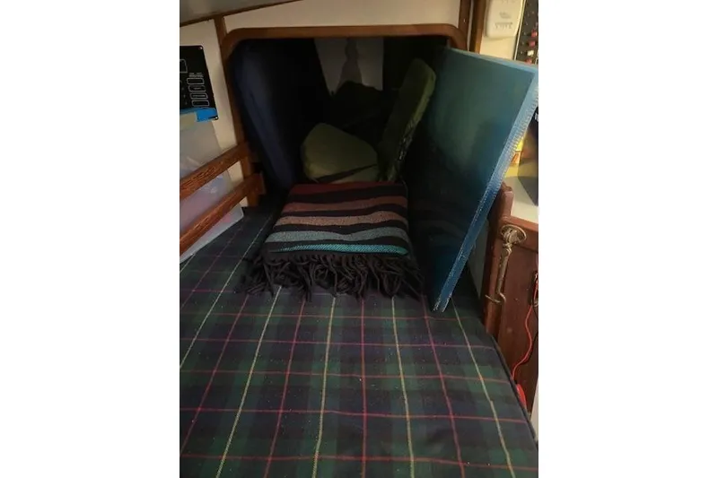 Slide: The Image of Cozy cabin interior of 1985 Bristol Channel Cutter 28 with plaid bedding and folded blanket. - 31