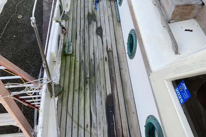 Slide: The Image of Weathered deck of a 1985 Bristol Channel Cutter 28 sailboat with green portholes. - 33