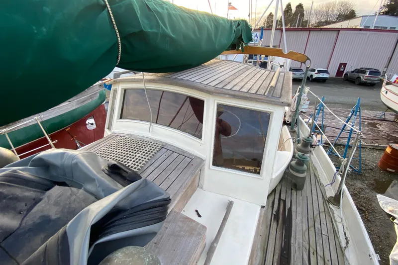 Slide: The Image of 1985 Bristol Channel Cutter 28 sailboat deck with green sail cover and wooden cabin. - 38