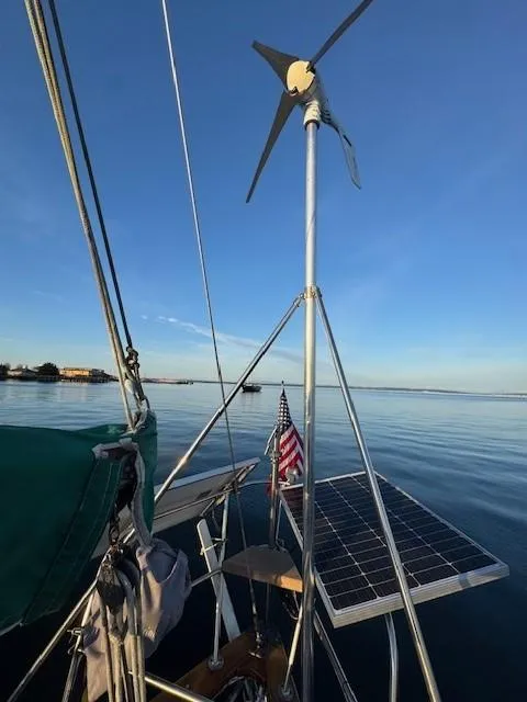 Slide: The Image of Bristol Channel Cutter 28 sailboat with solar panels and American flag on open water, 1985 model. - 4