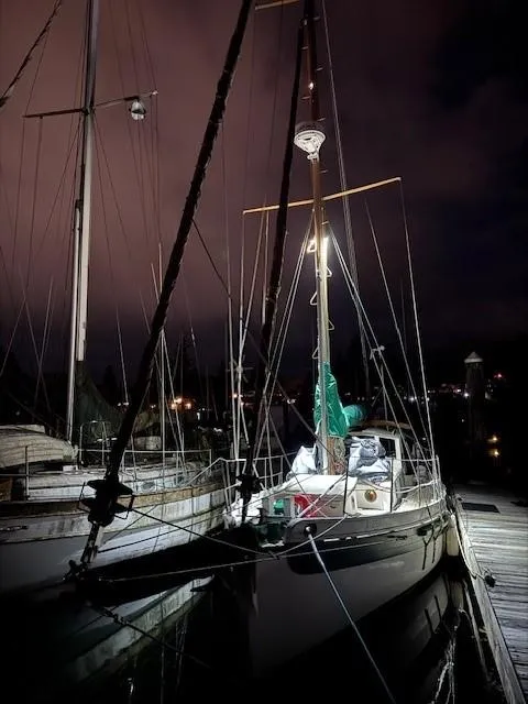 Slide: The Image of 1985 Bristol Channel Cutter 28 sailboat with red sails docked in a marina. - 6