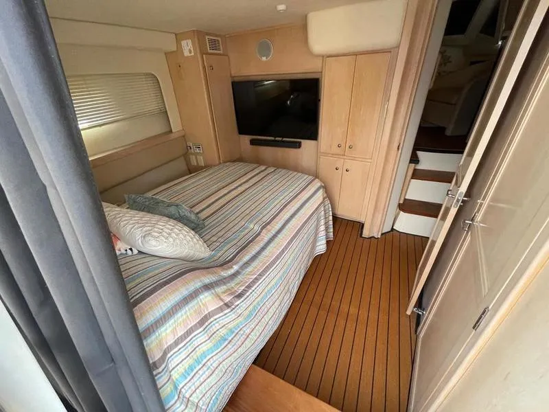Slide: The Image of 1997 Carver 400 CPMY cabin interior with bed, TV, and wooden flooring. - 13