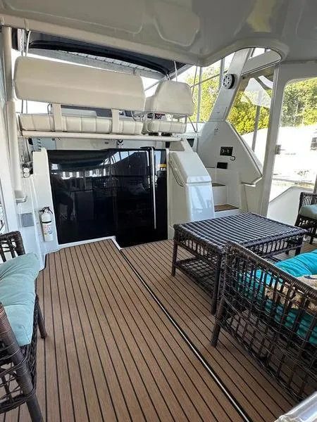 Slide: The Image of 1997 Carver 400 CPMY yacht interior with wicker furniture and wooden flooring. - 14