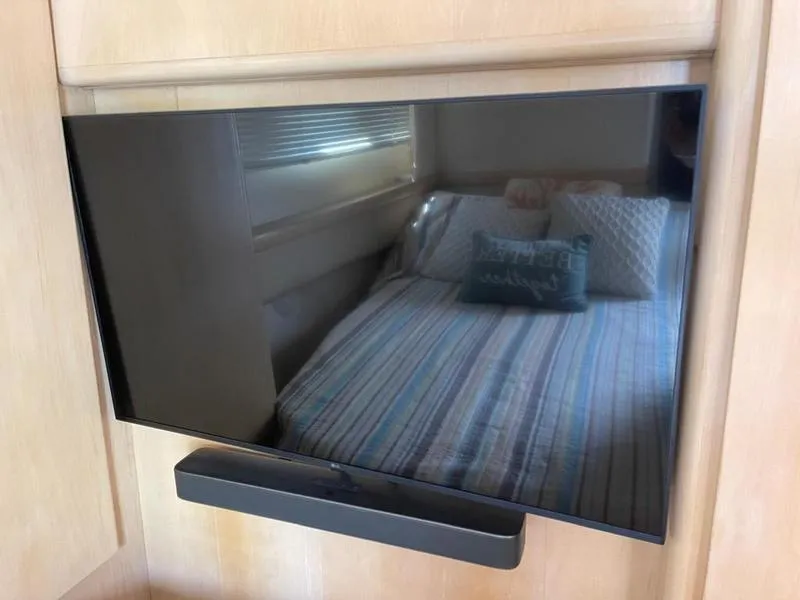 Slide: The Image of Flat-screen TV with soundbar reflecting a cozy bedroom in a 1997 Carver 400 CPMY yacht. - 16