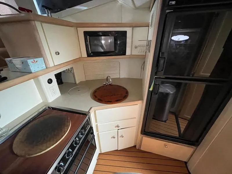 Slide: The Image of 1997 Carver 400 CPMY yacht kitchen with microwave, stove, and refrigerator. - 18
