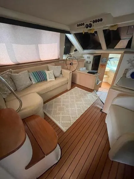 Slide: The Image of 1997 Carver 400 CPMY yacht interior with cozy seating, wooden flooring, and nautical decor. - 22