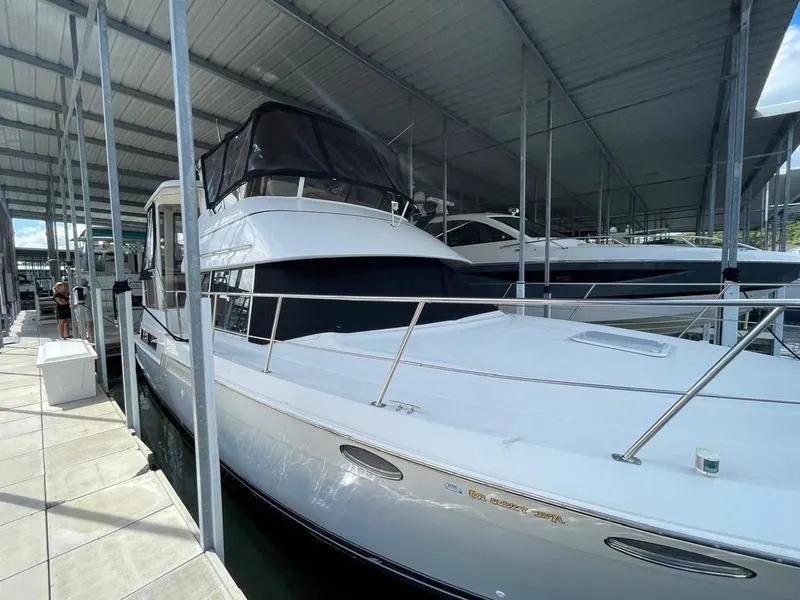 Slide: The Image of 1997 Carver 400 CPMY yacht docked in a covered marina. - 23