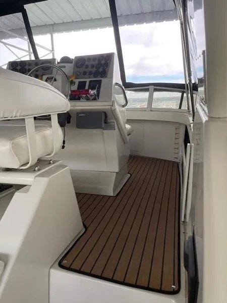 Slide: The Image of 1997 Carver 400 CPMY yacht helm with wooden deck and modern controls. - 26