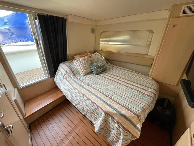 Slide: The Image of Cozy bedroom in 1997 Carver 400 CPMY yacht with striped bedding and wooden flooring. - 29