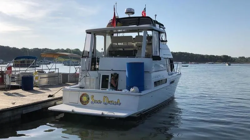 Slide: The Image of 1997 Carver 400 CPMY yacht docked at a marina, named "Sun Dazed." - 3