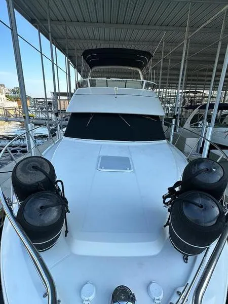 Slide: The Image of 1997 Carver 400 CPMY yacht docked under a covered marina. - 37