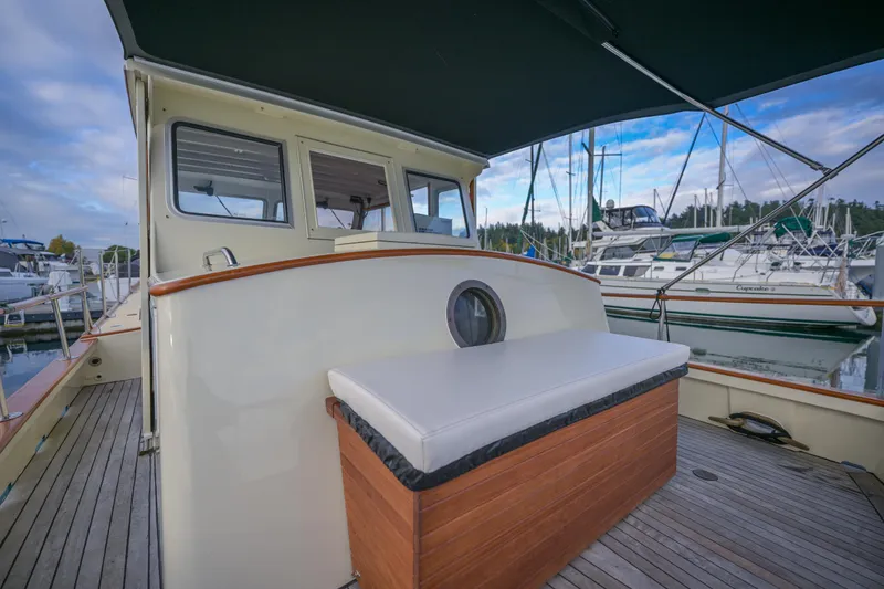 Slide: The Image of 1975 Rough Water 35 boat docked, featuring a wooden deck and cushioned seating. - 13