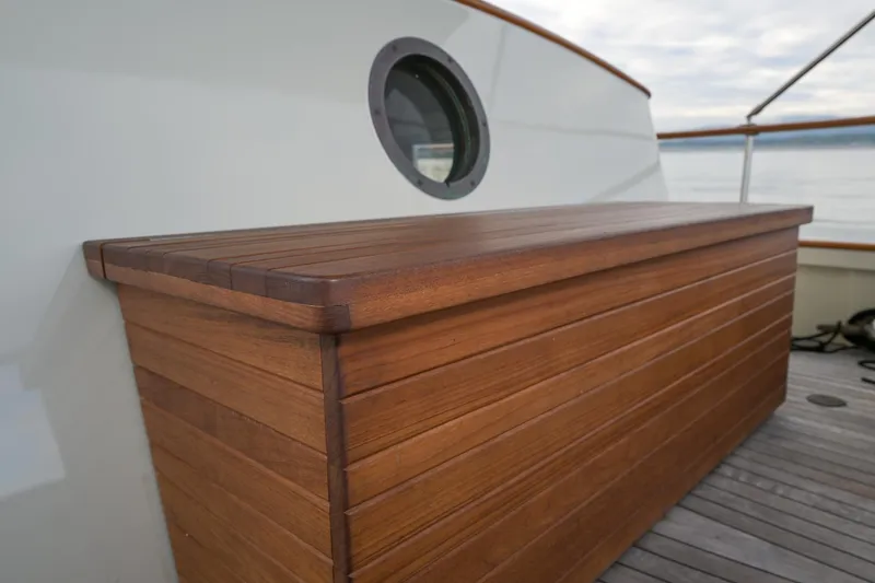 Slide: The Image of Wooden deck box on 1975 Rough Water 35 boat with porthole in background. - 15