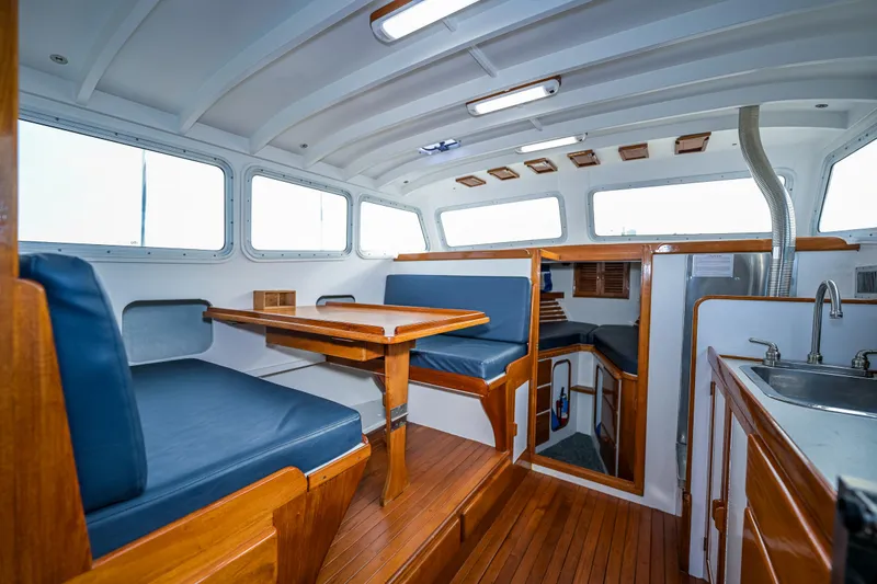 Slide: The Image of Interior of a 1975 Rough Water 35 boat with wooden furnishings and blue seating. - 22