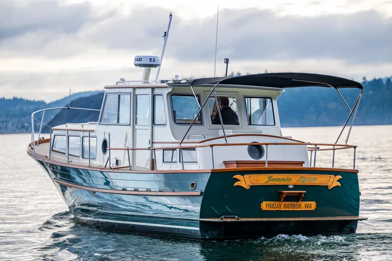 Slide: The Image of Classic 1975 Rough Water 35 boat cruising on a calm lake with scenic background. - 3
