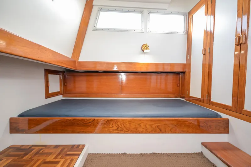 Slide: The Image of Interior cabin of 1975 Rough Water 35 boat with wooden finishes and a single bed. - 30
