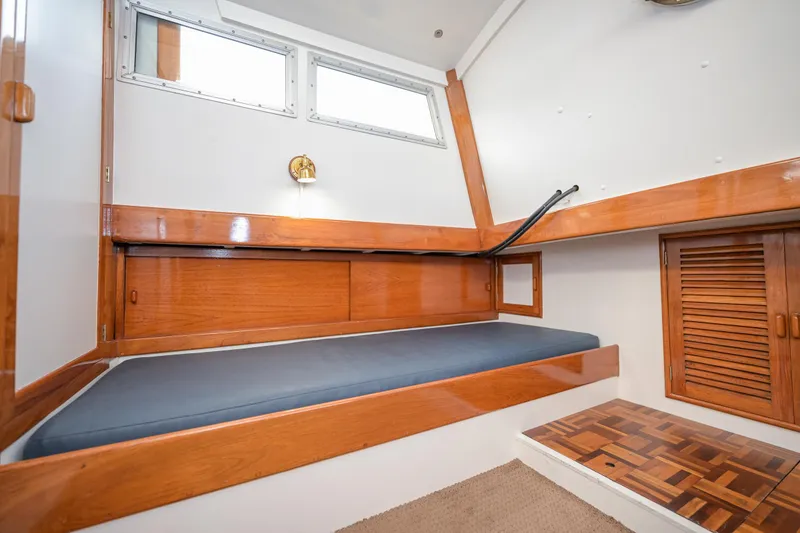 Slide: The Image of Cozy cabin interior of 1975 Rough Water 35 boat with wooden accents and a single bed. - 31