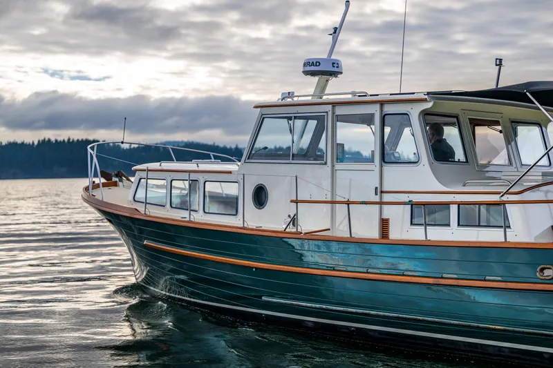 Slide: The Image of Classic 1975 Rough Water 35 boat cruising on calm waters under cloudy skies. - 5