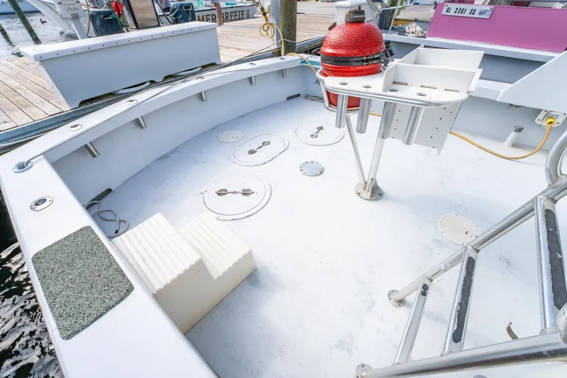 Slide: The Image of 1983 Resmondo 38 boat deck with storage hatches and seating, docked at marina. - 12