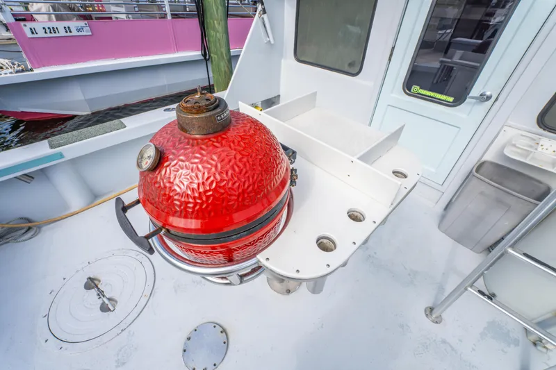 Slide: The Image of Red grill on 1983 Resmondo 38 boat deck with seating and storage. - 13