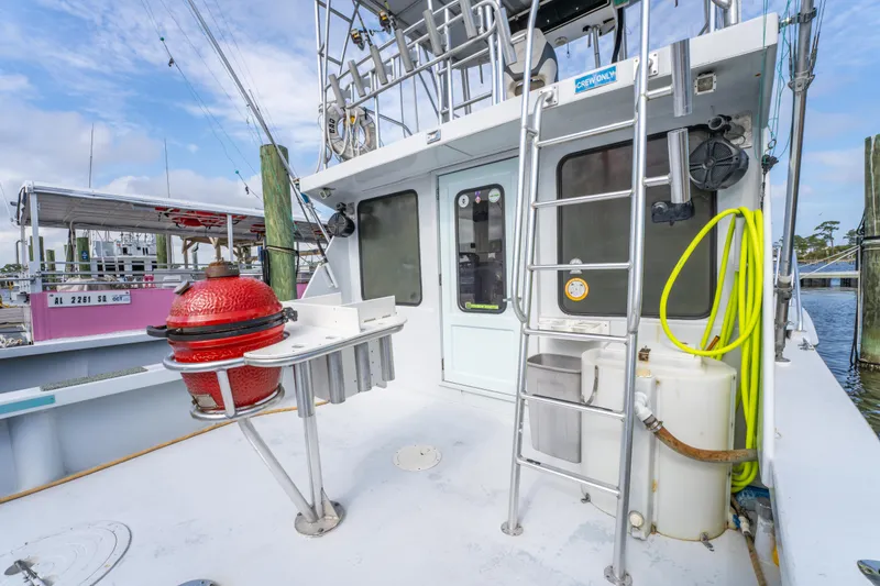Slide: The Image of 1983 Resmondo 38 boat deck with ladder, red equipment, and docked surroundings. - 14
