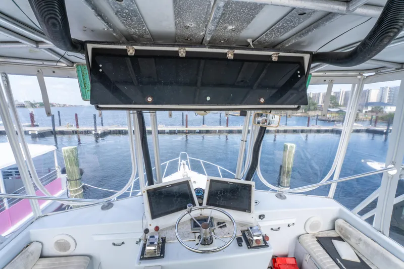 Slide: The Image of Helm of 1983 Resmondo 38 boat with dual screens and steering wheel, dockside view. - 20