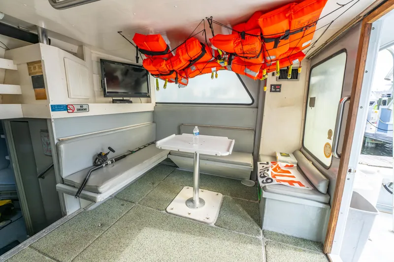 Slide: The Image of Interior of 1983 Resmondo 38 boat with life jackets, seating, and table. - 23