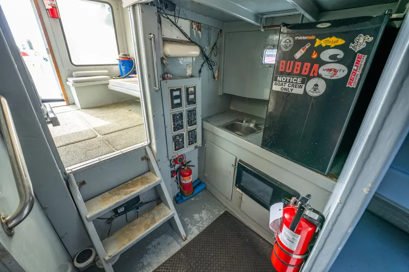 Slide: The Image of Interior of 1983 Resmondo 38 boat with kitchenette, stairs, and safety equipment. - 26
