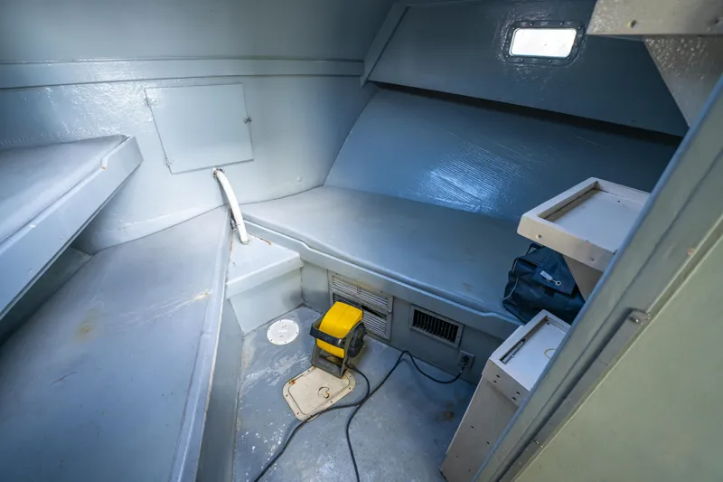 Slide: The Image of Interior cabin of 1983 Resmondo 38 boat, featuring simple sleeping and storage areas. - 28