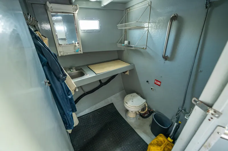 Slide: The Image of Compact bathroom in a 1983 Resmondo 38 boat with sink, toilet, and storage shelves. - 29