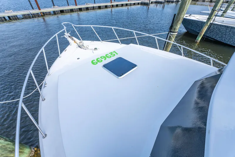 Slide: The Image of Bow of 1983 Resmondo 38 boat docked at marina, featuring railing and hatch. - 30