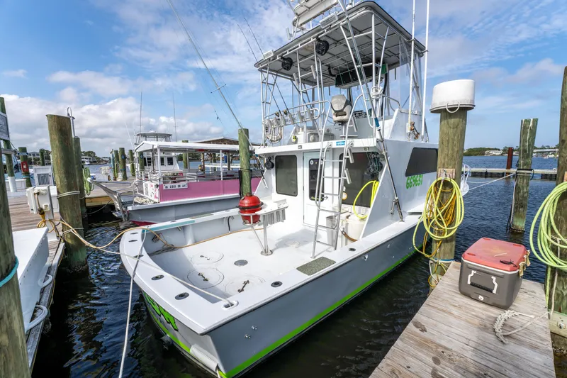 Slide: The Image of 1983 Resmondo 38 boat docked at marina, featuring spacious deck and tower. - 33