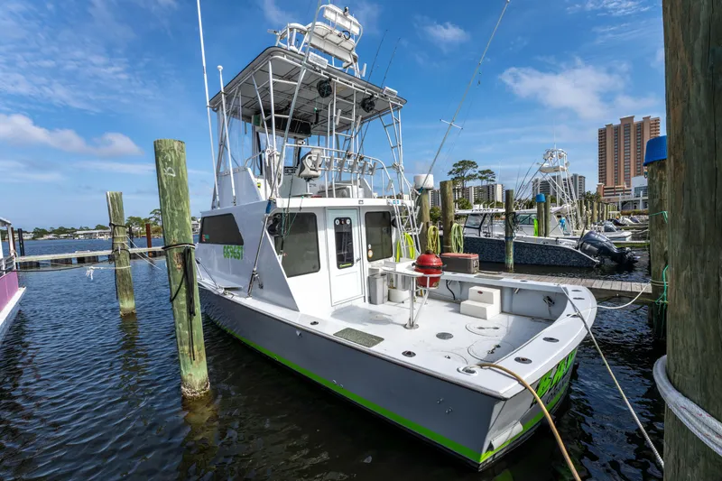 Slide: The Image of 1983 Resmondo 38 boat docked at marina, clear sky, waterfront buildings in background. - 35
