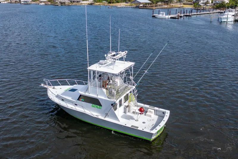 Slide: The Image of 1983 Resmondo 38 boat on calm water, featuring a spacious deck and fishing equipment. - 37