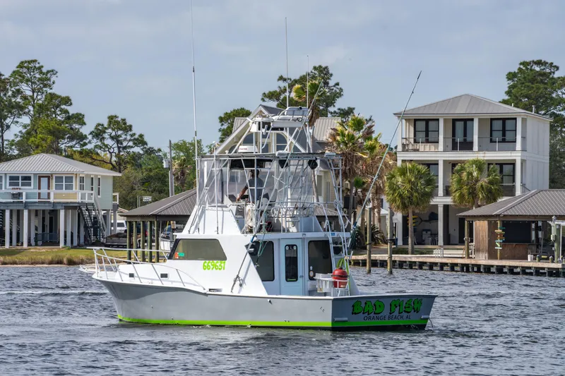 Slide: The Image of 1983 Resmondo 38 boat cruising near waterfront homes, featuring fishing equipment and antennas. - 5